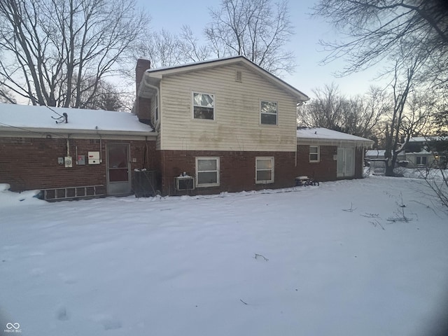 snow covered property with cooling unit