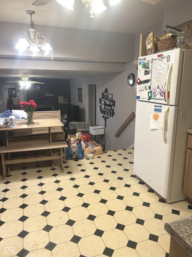 basement featuring an inviting chandelier and white fridge