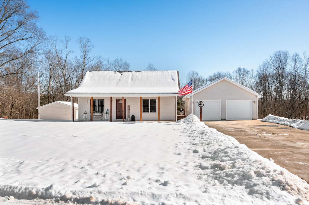 ranch-style home featuring a garage, an outbuilding, and covered porch