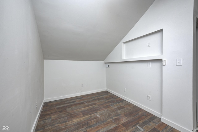 bonus room featuring vaulted ceiling and dark wood-type flooring