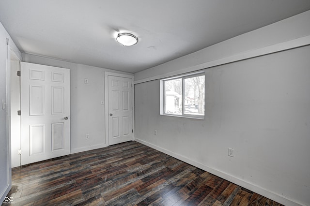 unfurnished room with dark wood-type flooring