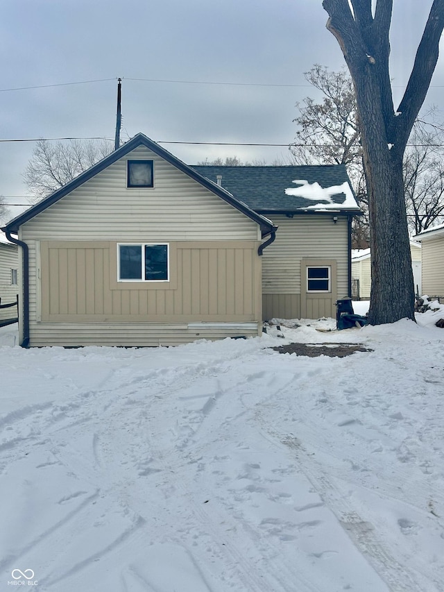 view of snow covered rear of property