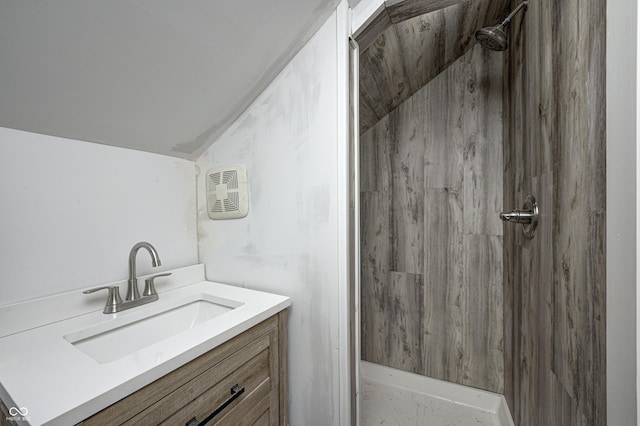 bathroom featuring tiled shower and vanity