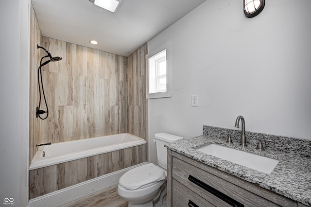 full bathroom featuring toilet, tiled shower / bath, vanity, and hardwood / wood-style flooring