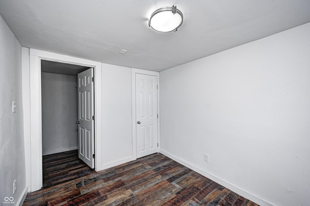 unfurnished bedroom with a closet and dark hardwood / wood-style flooring