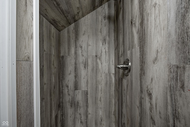 interior details featuring a tile shower