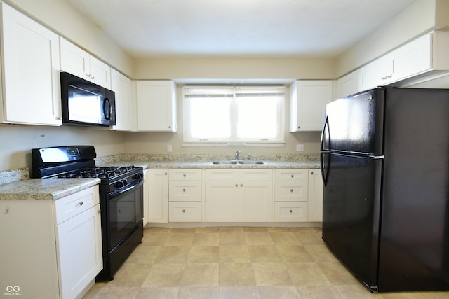 kitchen with sink, white cabinetry, black appliances, and light stone counters