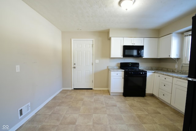 kitchen with white cabinets, light stone countertops, and black appliances