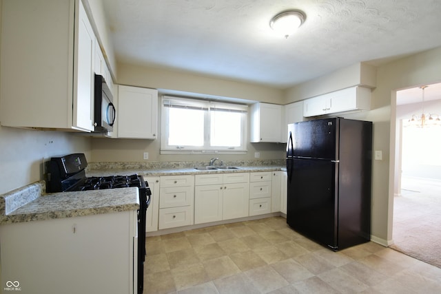 kitchen featuring black appliances, a chandelier, white cabinets, and sink