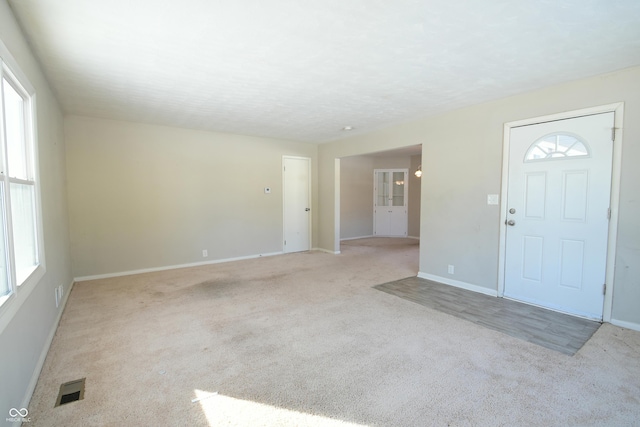 entrance foyer featuring light colored carpet