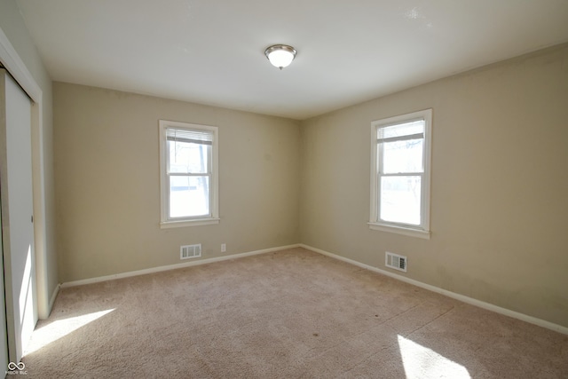 empty room with light carpet and plenty of natural light