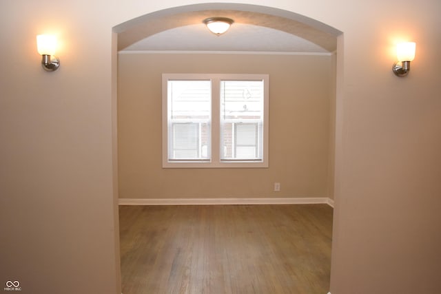 spare room featuring hardwood / wood-style flooring and crown molding