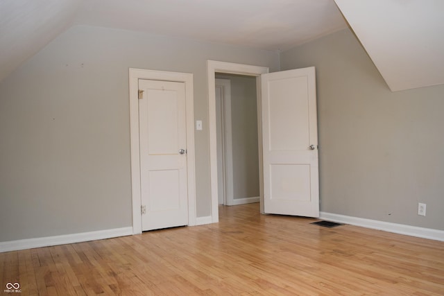 bonus room with light hardwood / wood-style flooring and lofted ceiling