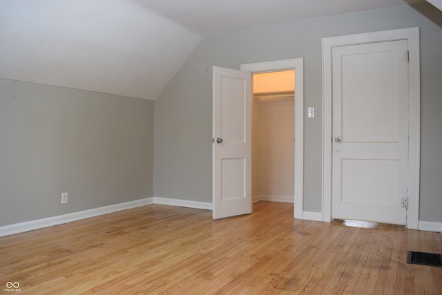 bonus room featuring light wood-type flooring and vaulted ceiling