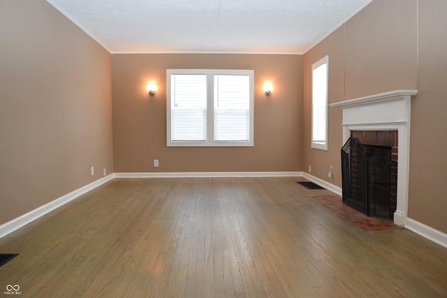 unfurnished living room featuring a fireplace, hardwood / wood-style flooring, and crown molding