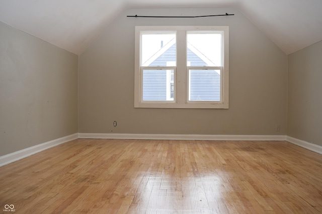 additional living space featuring lofted ceiling and light hardwood / wood-style floors