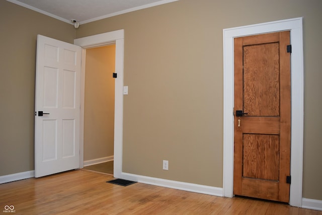 unfurnished room with crown molding and light hardwood / wood-style flooring