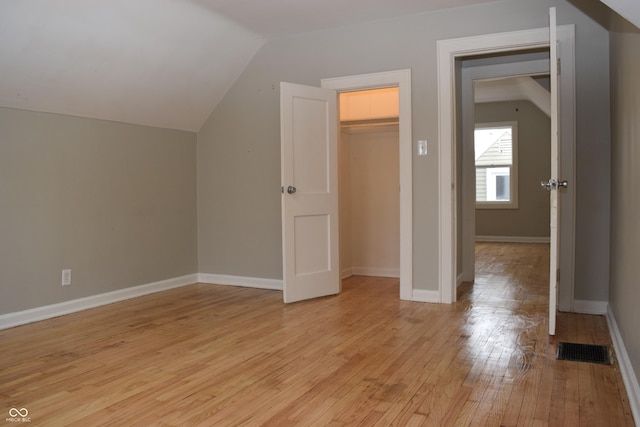 additional living space featuring vaulted ceiling and light hardwood / wood-style floors