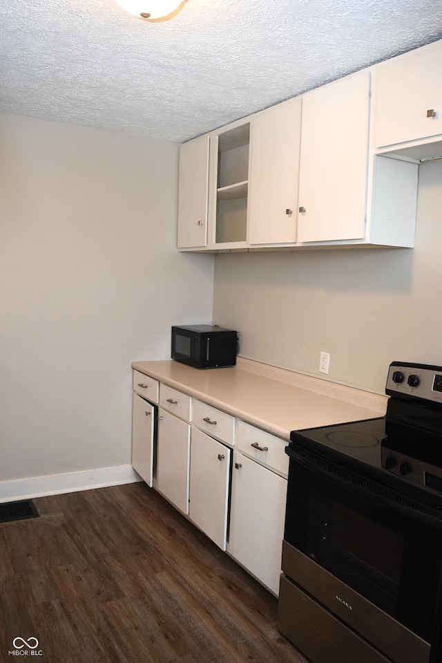 kitchen with white cabinets, stainless steel electric stove, a textured ceiling, and dark hardwood / wood-style floors