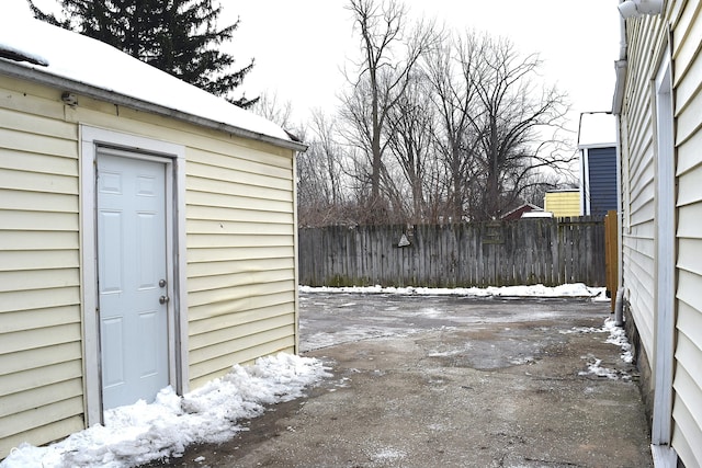 snow covered patio with a storage shed