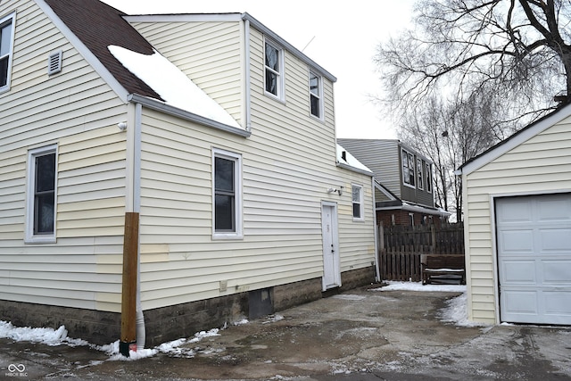 view of snowy exterior featuring a garage