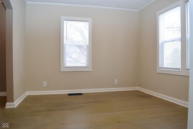 spare room featuring ornamental molding, hardwood / wood-style flooring, and plenty of natural light