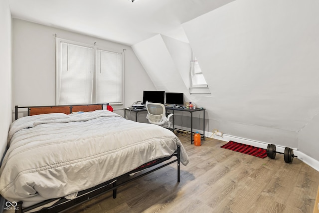 bedroom featuring light hardwood / wood-style flooring and lofted ceiling