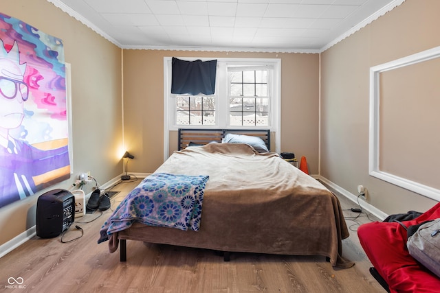 bedroom with hardwood / wood-style flooring and crown molding