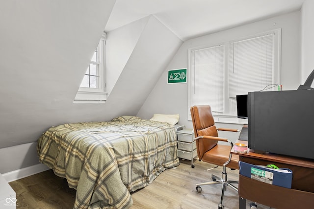 bedroom with light hardwood / wood-style floors and vaulted ceiling