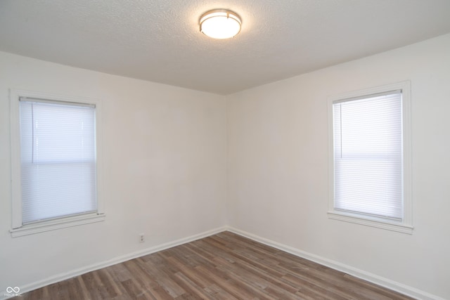 empty room featuring dark hardwood / wood-style flooring and a textured ceiling