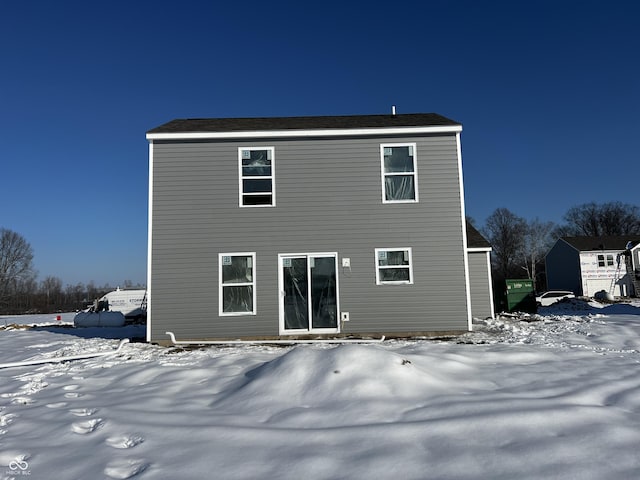 view of snow covered back of property