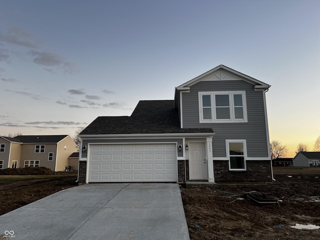 traditional home with driveway, an attached garage, a shingled roof, and brick siding