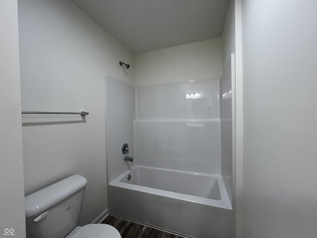 full bath featuring shower / bathtub combination, wood finished floors, and toilet