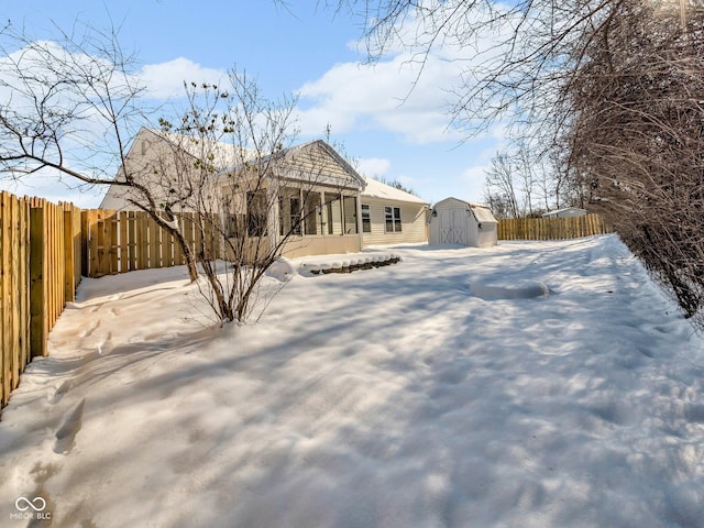 yard layered in snow with a shed