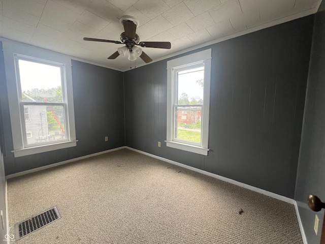 unfurnished room featuring carpet, ceiling fan, and crown molding