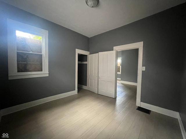 unfurnished bedroom featuring wood-type flooring and a closet