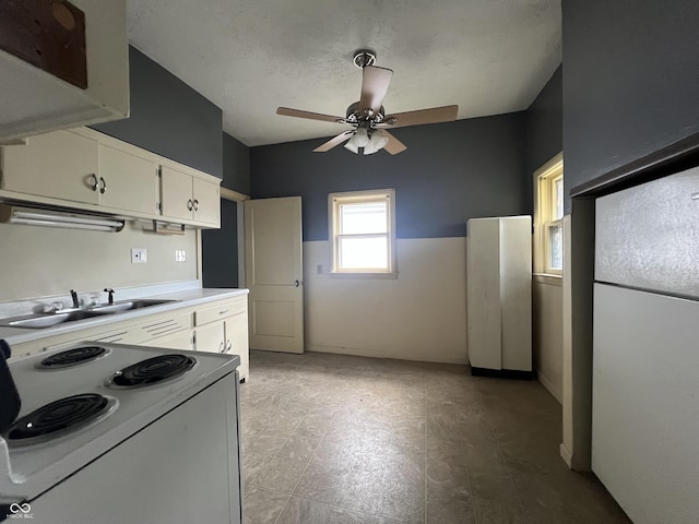 kitchen featuring white cabinets, ceiling fan, white appliances, and sink