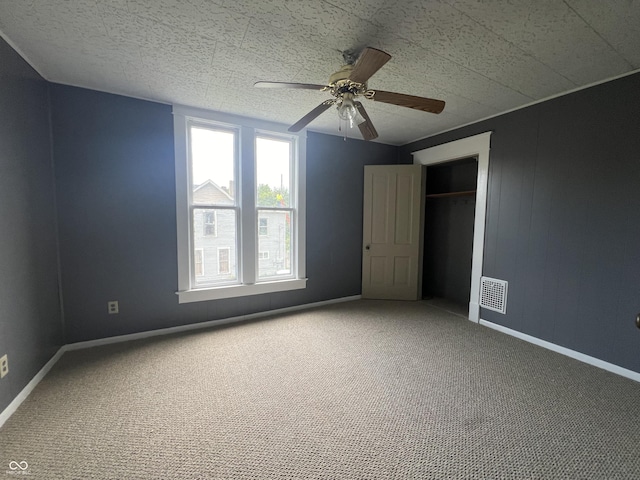 unfurnished bedroom with carpet flooring, ceiling fan, and a closet