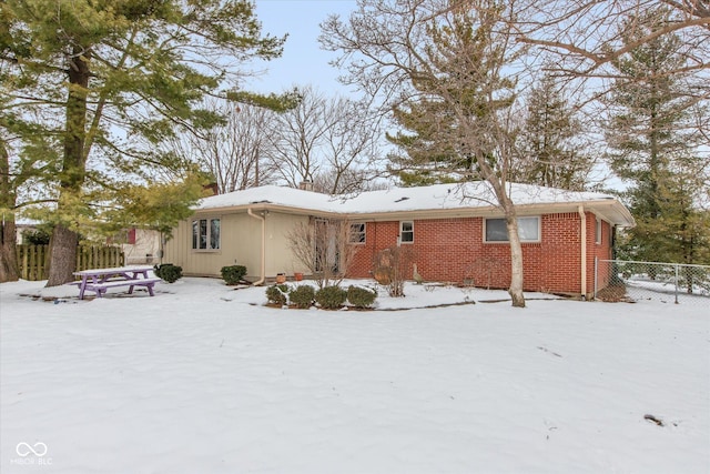 view of snow covered back of property