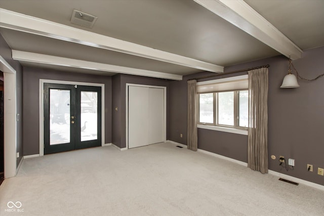 unfurnished bedroom featuring light carpet, access to outside, french doors, and beamed ceiling