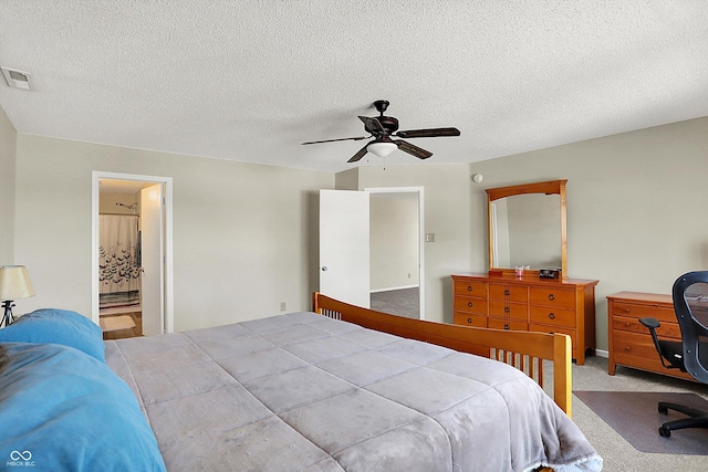 carpeted bedroom featuring ceiling fan, connected bathroom, and a textured ceiling