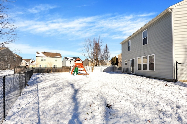 snowy yard featuring a playground