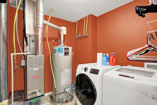 clothes washing area with washer and dryer, a textured ceiling, and gas water heater