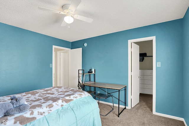 bedroom featuring a textured ceiling, a spacious closet, ceiling fan, a closet, and light colored carpet