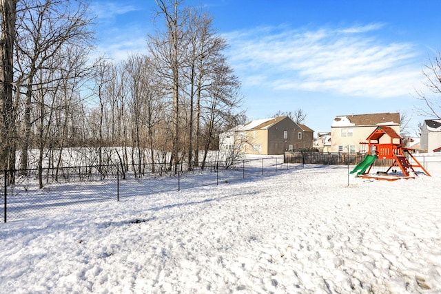 yard layered in snow with a playground