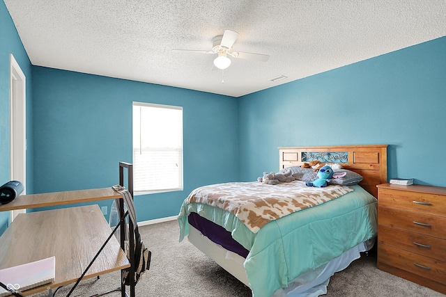 bedroom with ceiling fan, carpet, and a textured ceiling