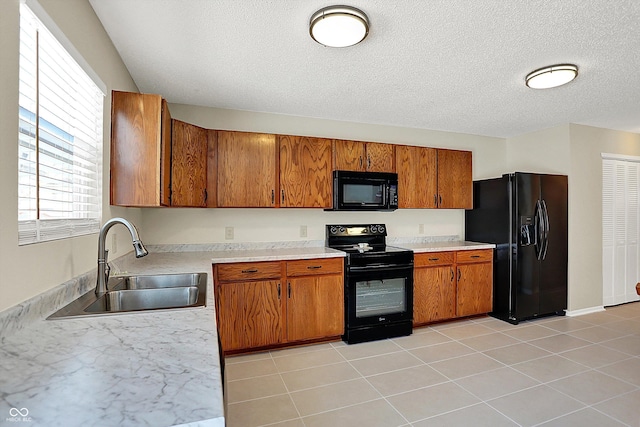 kitchen featuring black appliances, a textured ceiling, sink, and light tile patterned floors