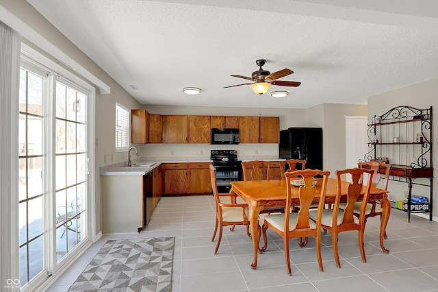 kitchen with black appliances, ceiling fan, sink, and light tile patterned floors