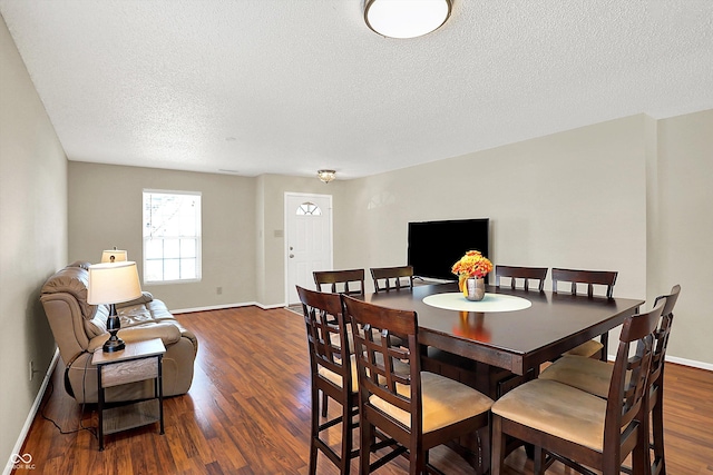 dining room featuring a textured ceiling and dark hardwood / wood-style floors