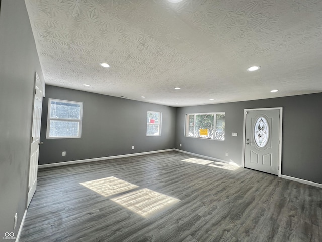 foyer entrance featuring a textured ceiling and dark hardwood / wood-style flooring